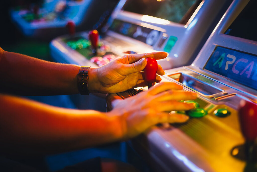 Arcade game persons hands shown playing the game