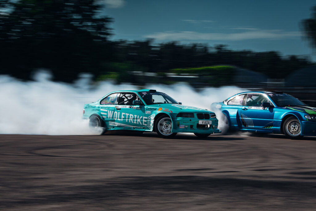 Two races cars with smoke behind them