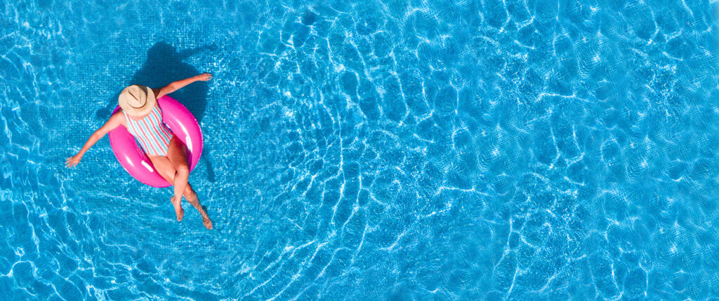 Woman on a pink float in the middle of a pool