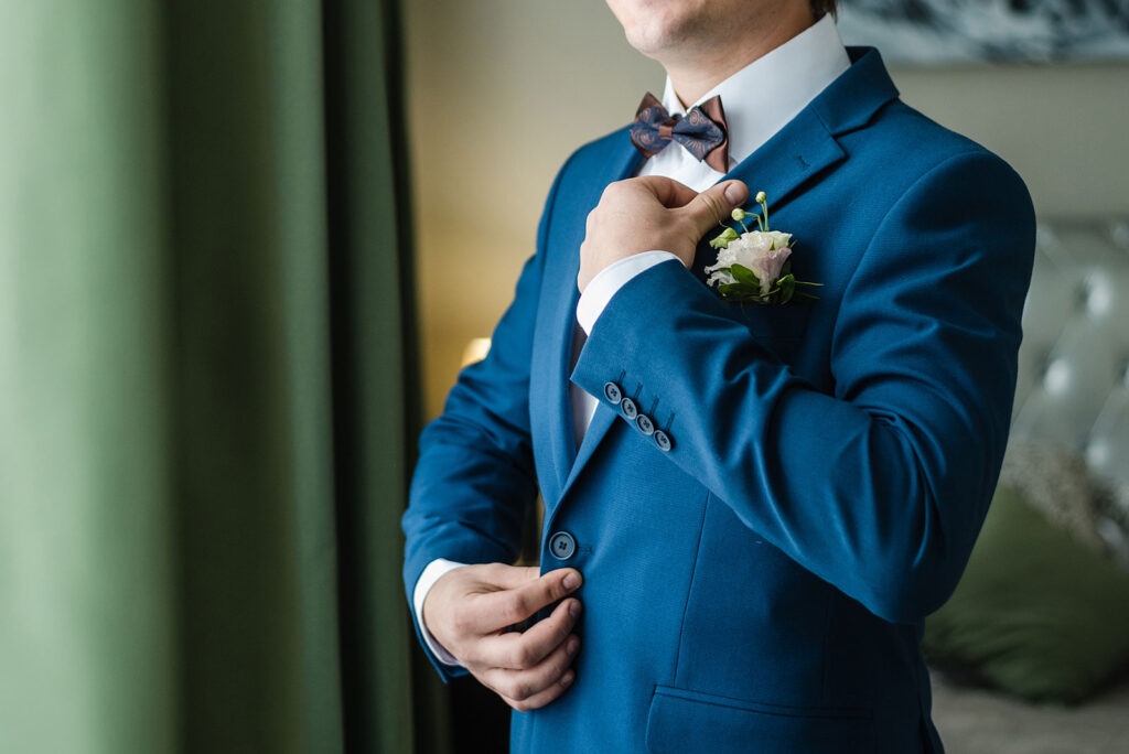 Man in tux adjusting his suit